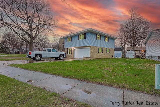 view of side of home with a yard, an attached garage, and driveway
