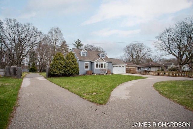 cape cod-style house with fence, an attached garage, driveway, and a front yard