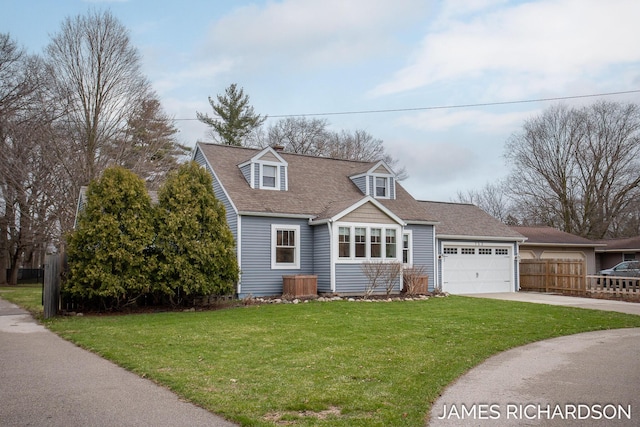 cape cod house featuring an attached garage, driveway, fence, and a front yard