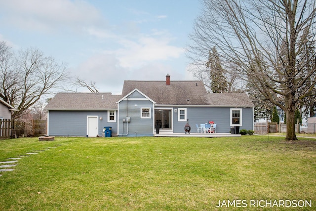 rear view of house featuring fence, a fire pit, and a yard