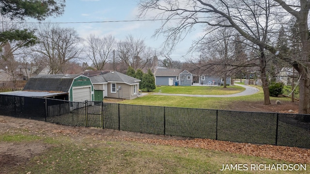 view of yard with a gate, fence, an outbuilding, and a garage