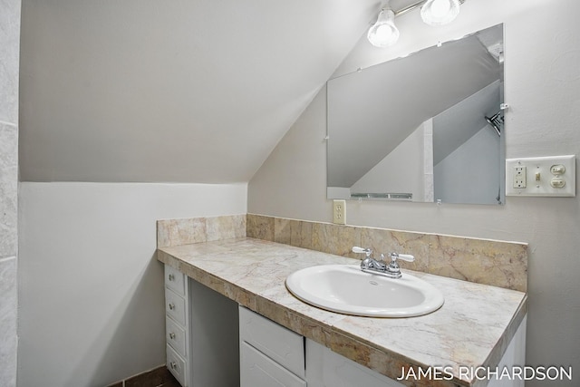 bathroom with lofted ceiling and vanity