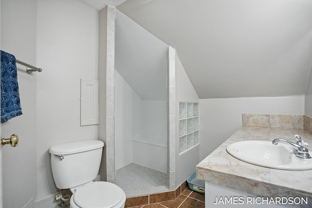 bathroom with tile patterned floors, vanity, walk in shower, toilet, and lofted ceiling