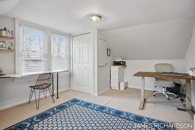 office area featuring vaulted ceiling, carpet, and baseboards