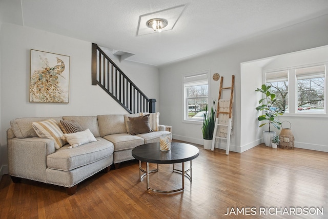 living room with plenty of natural light, baseboards, wood finished floors, and stairway
