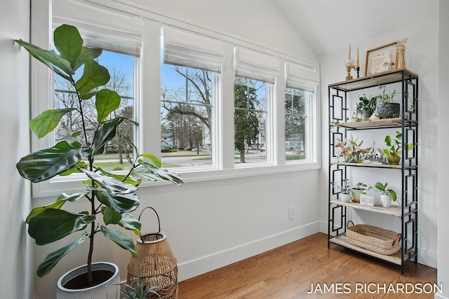 sitting room featuring lofted ceiling, baseboards, and wood finished floors