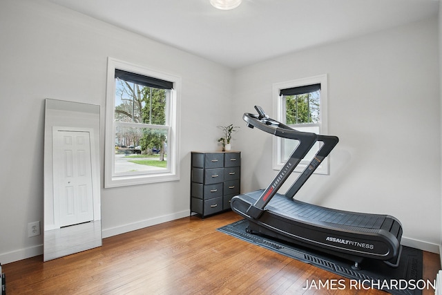 workout area with wood-type flooring, a wealth of natural light, and baseboards