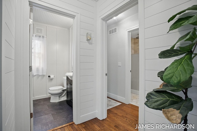 bathroom with wood finished floors, visible vents, toilet, and vanity