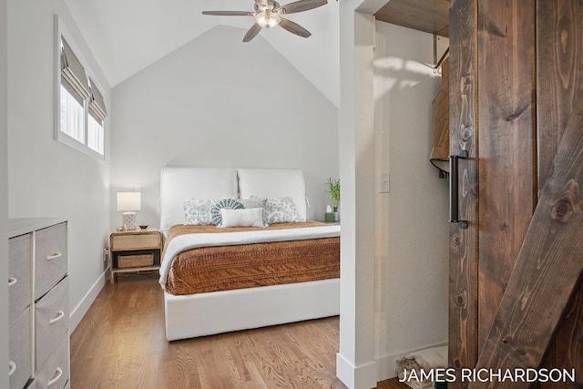 bedroom featuring vaulted ceiling, wood finished floors, a ceiling fan, and baseboards
