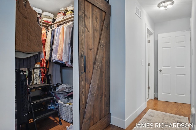 walk in closet with wood finished floors and visible vents