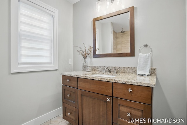 bathroom with tile patterned flooring, baseboards, and vanity