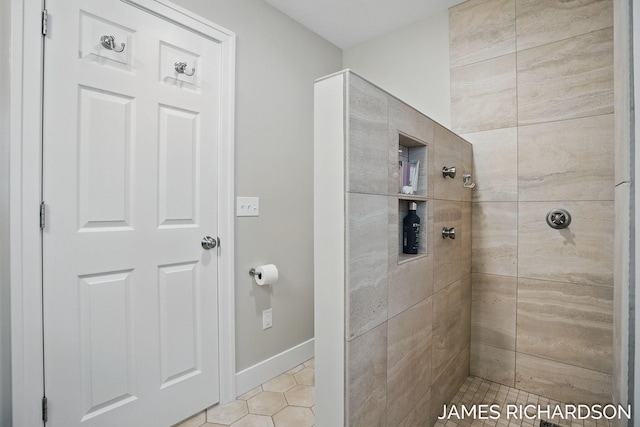 full bathroom featuring baseboards, tile patterned floors, and tiled shower
