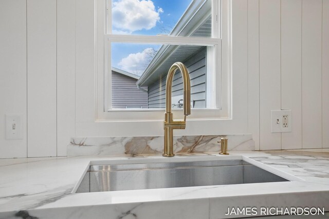 interior details with light stone counters and a sink