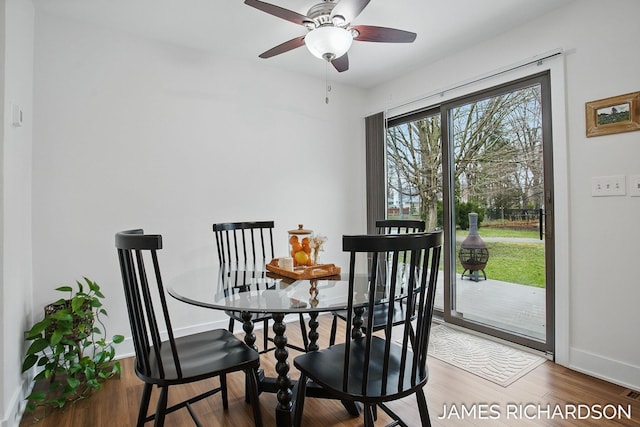 dining room featuring wood finished floors, baseboards, and a ceiling fan