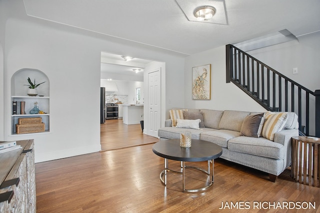 living room with wood finished floors and stairs