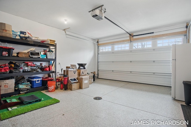 garage featuring freestanding refrigerator and a garage door opener