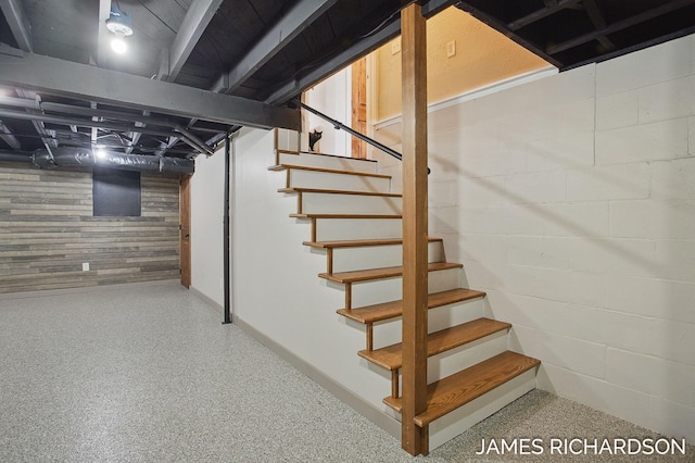 basement featuring stairs and concrete block wall