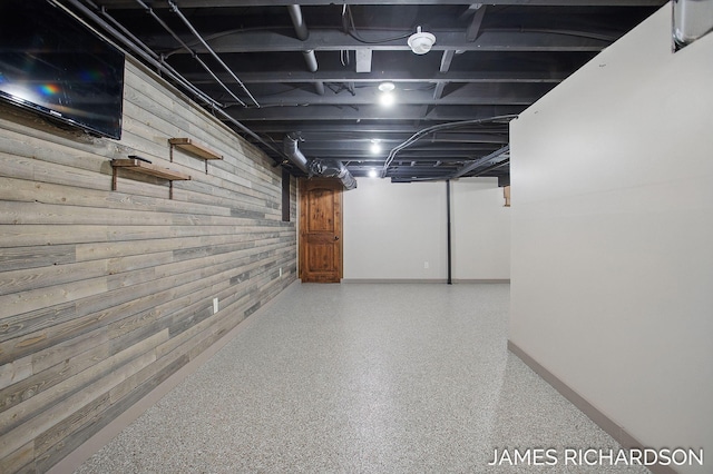 finished basement with baseboards and wooden walls