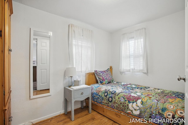 bedroom featuring baseboards and light wood-style floors