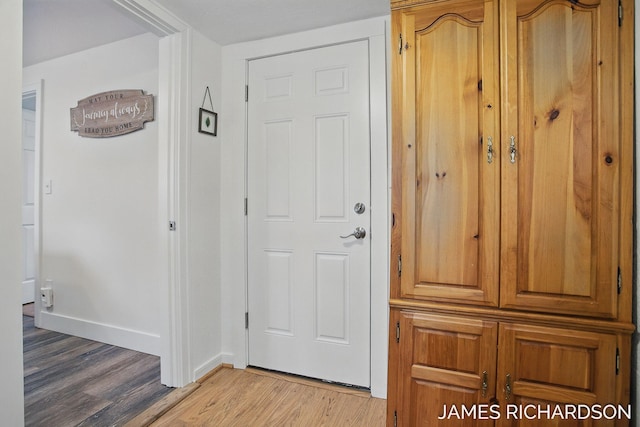 doorway featuring light wood-style flooring and baseboards