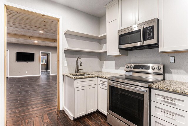 62711 Balk Rd, Sturgis, MI 49091 - kitchen with stainless steel appliances, a sink, light stone countertops, dark wood-style flooring, and baseboards