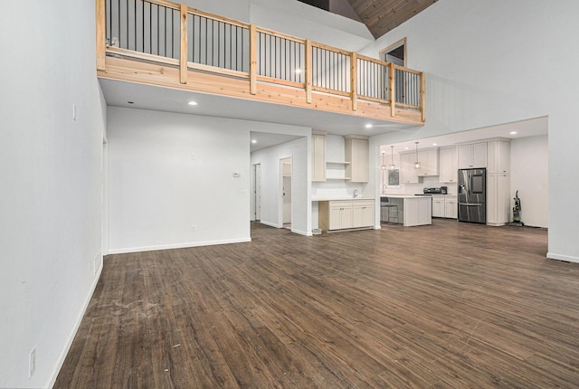 62711 Balk Rd, Sturgis, MI 49091 - unfurnished living room with high vaulted ceiling, dark wood-type flooring, baseboards, and recessed lighting