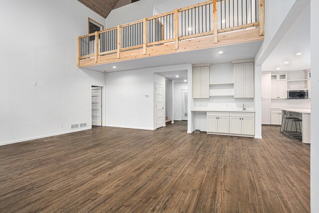 62711 Balk Rd, Sturgis, MI 49091 - unfurnished living room featuring high vaulted ceiling, dark wood-style floors, baseboards, and recessed lighting