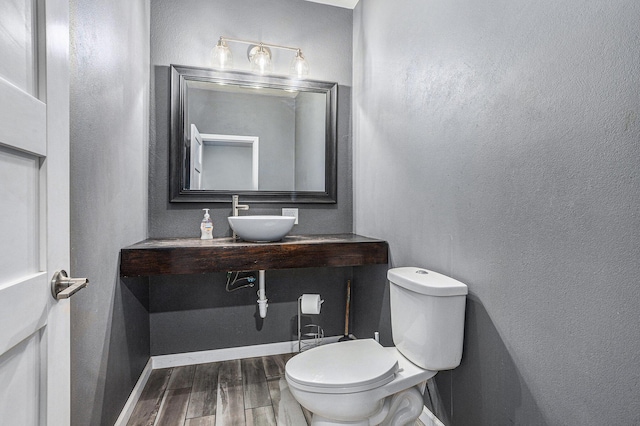 62711 Balk Rd, Sturgis, MI 49091 - half bath featuring a sink, wood finished floors, toilet, and baseboards