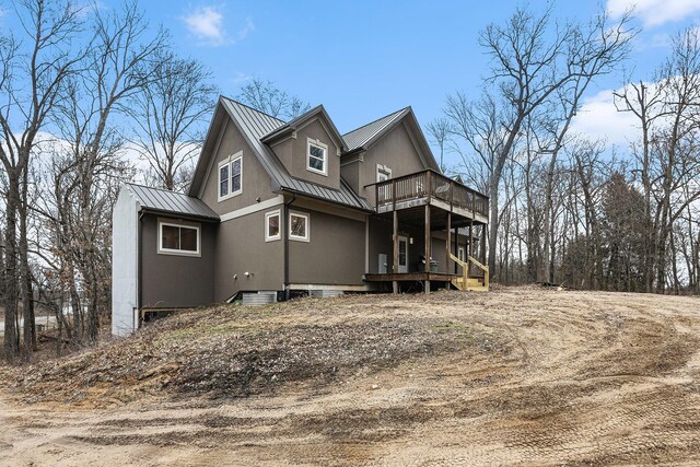 62711 Balk Rd, Sturgis, MI 49091 - view of side of property with a standing seam roof, metal roof, a wooden deck, stucco siding, and a balcony