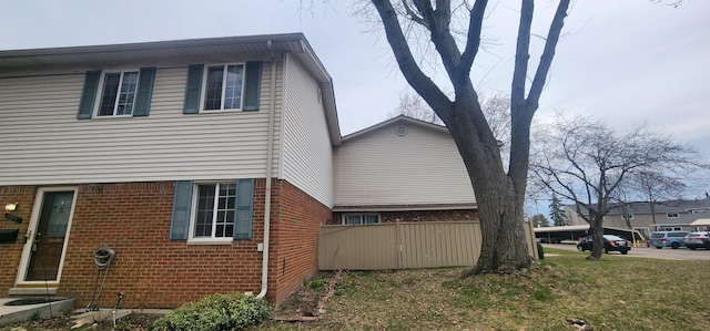 889 Kirts Blvd, Troy, MI 48084 - view of property exterior featuring brick siding, fence, and a yard