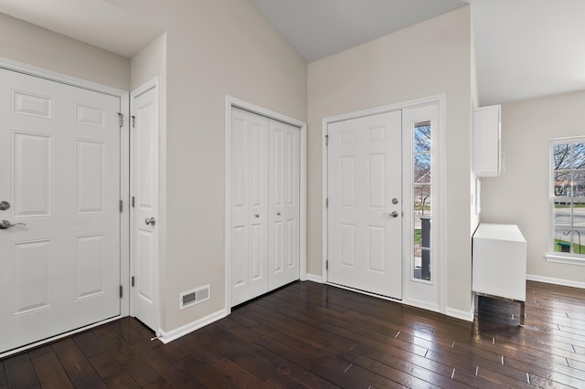 entrance foyer featuring baseboards, visible vents, and dark wood-type flooring