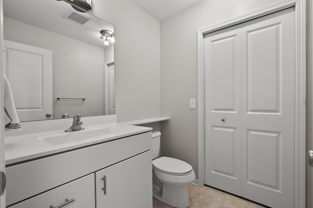 half bath with vanity, tile patterned flooring, toilet, and visible vents