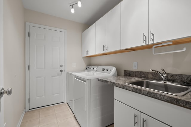 washroom with baseboards, a sink, cabinet space, independent washer and dryer, and light tile patterned floors