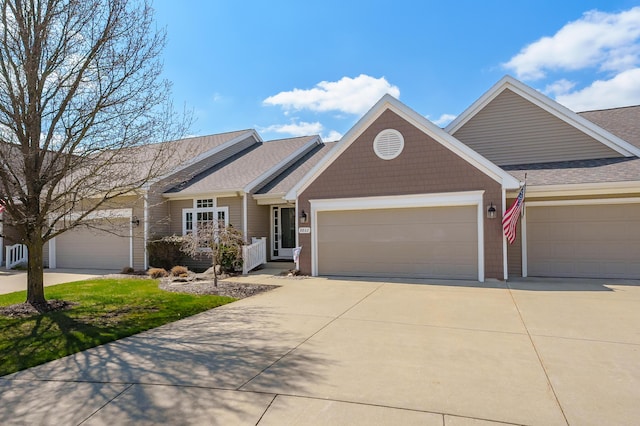 view of front of house featuring a shingled roof, an attached garage, and driveway