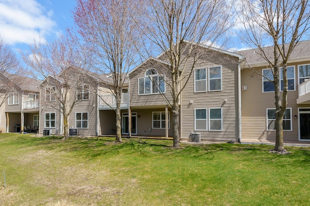 back of property featuring a lawn and cooling unit