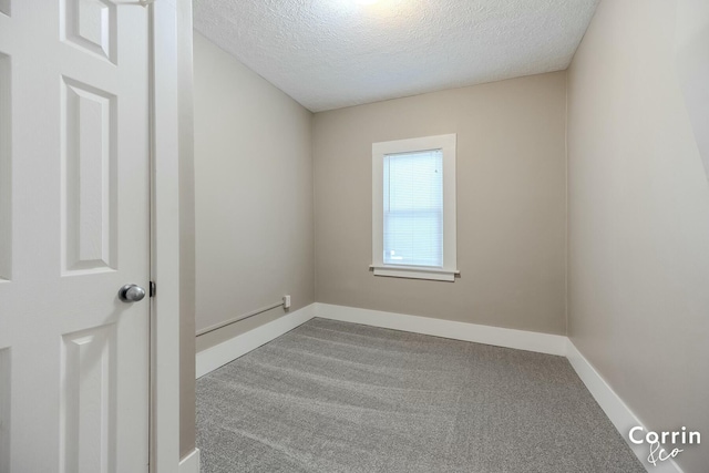 empty room with baseboards, carpet flooring, and a textured ceiling