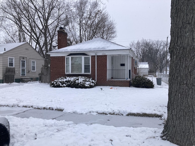19015 Kingsville St, Harper Woods, MI 48225 - bungalow-style home featuring brick siding, a chimney, fence, and a porch
