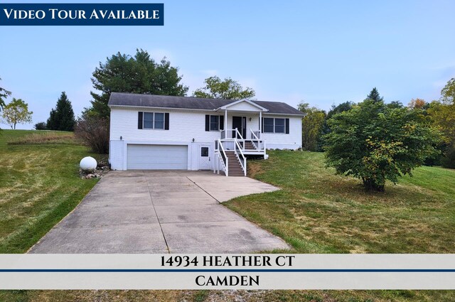 view of front of home featuring driveway, an attached garage, and a front yard