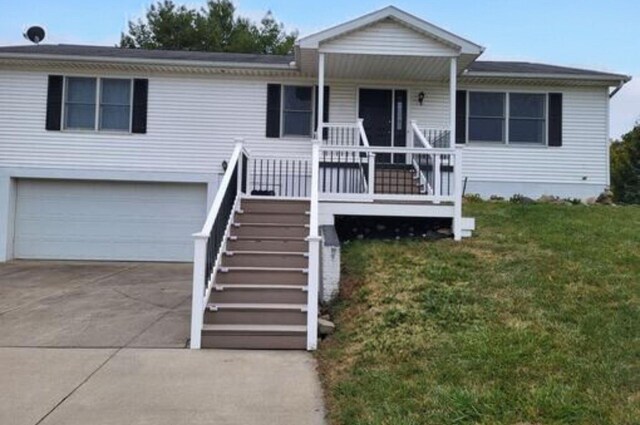 view of front of home with covered porch, stairway, concrete driveway, a front lawn, and a garage