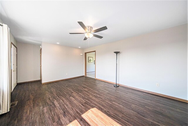 spare room featuring a ceiling fan, baseboards, and wood finished floors