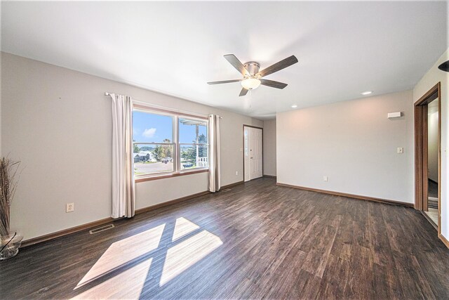 unfurnished room featuring baseboards, visible vents, and dark wood-type flooring