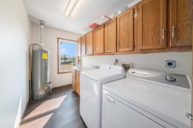 washroom with dark wood-style flooring, baseboards, water heater, cabinet space, and washer and clothes dryer
