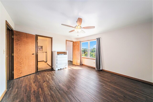 unfurnished bedroom featuring baseboards, dark wood-style floors, and ceiling fan