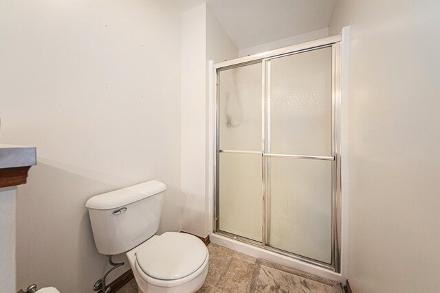 full bath featuring a shower with shower door and toilet