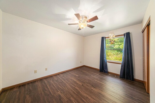 unfurnished room with a ceiling fan, wood finished floors, baseboards, and visible vents