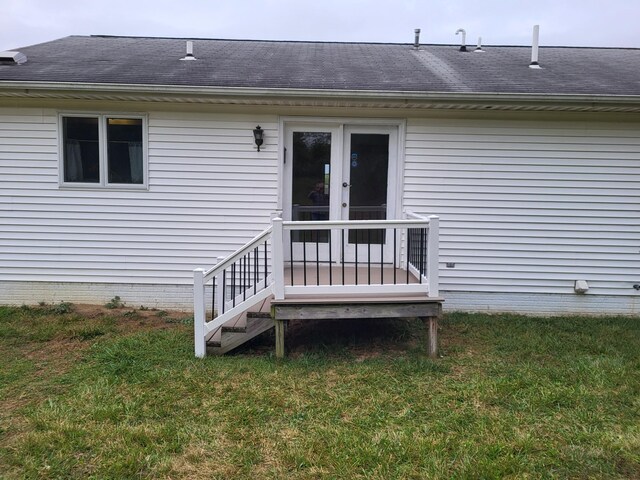property entrance featuring french doors, roof with shingles, and a yard