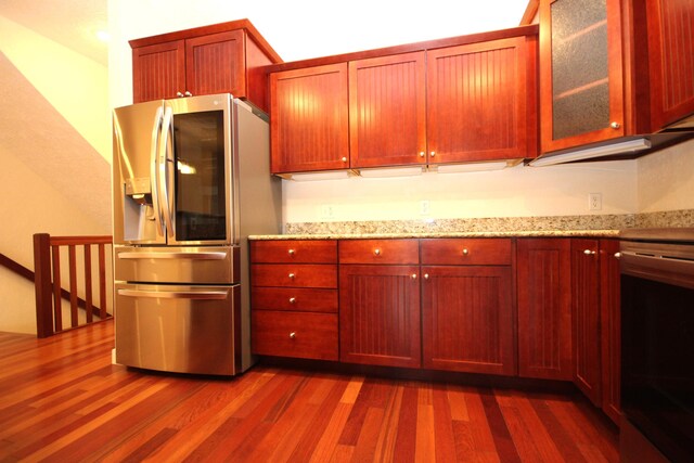 14224 Bridgeview Pointe, Vicksburg, MI 49097 - kitchen featuring stainless steel refrigerator with ice dispenser, dark wood-type flooring, stove, and light stone counters