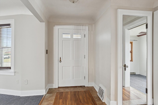 foyer entrance featuring baseboards, visible vents, and a healthy amount of sunlight
