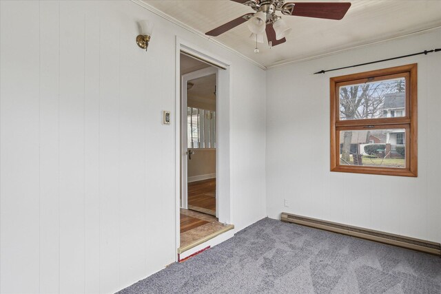 carpeted empty room featuring a baseboard radiator, crown molding, and a ceiling fan
