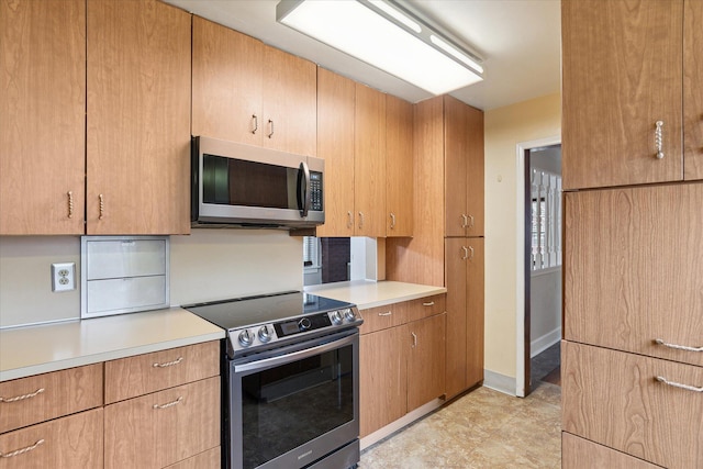 kitchen with light countertops, appliances with stainless steel finishes, and baseboards